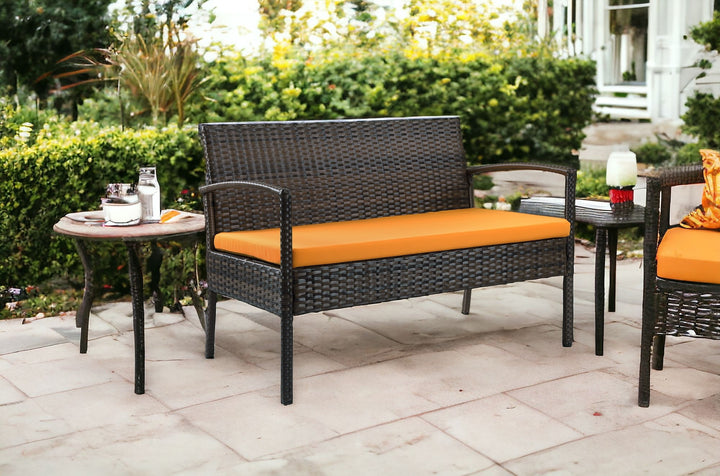 Four Piece Outdoor Brown Wicker Sofa Seating Group with Orange Cushions